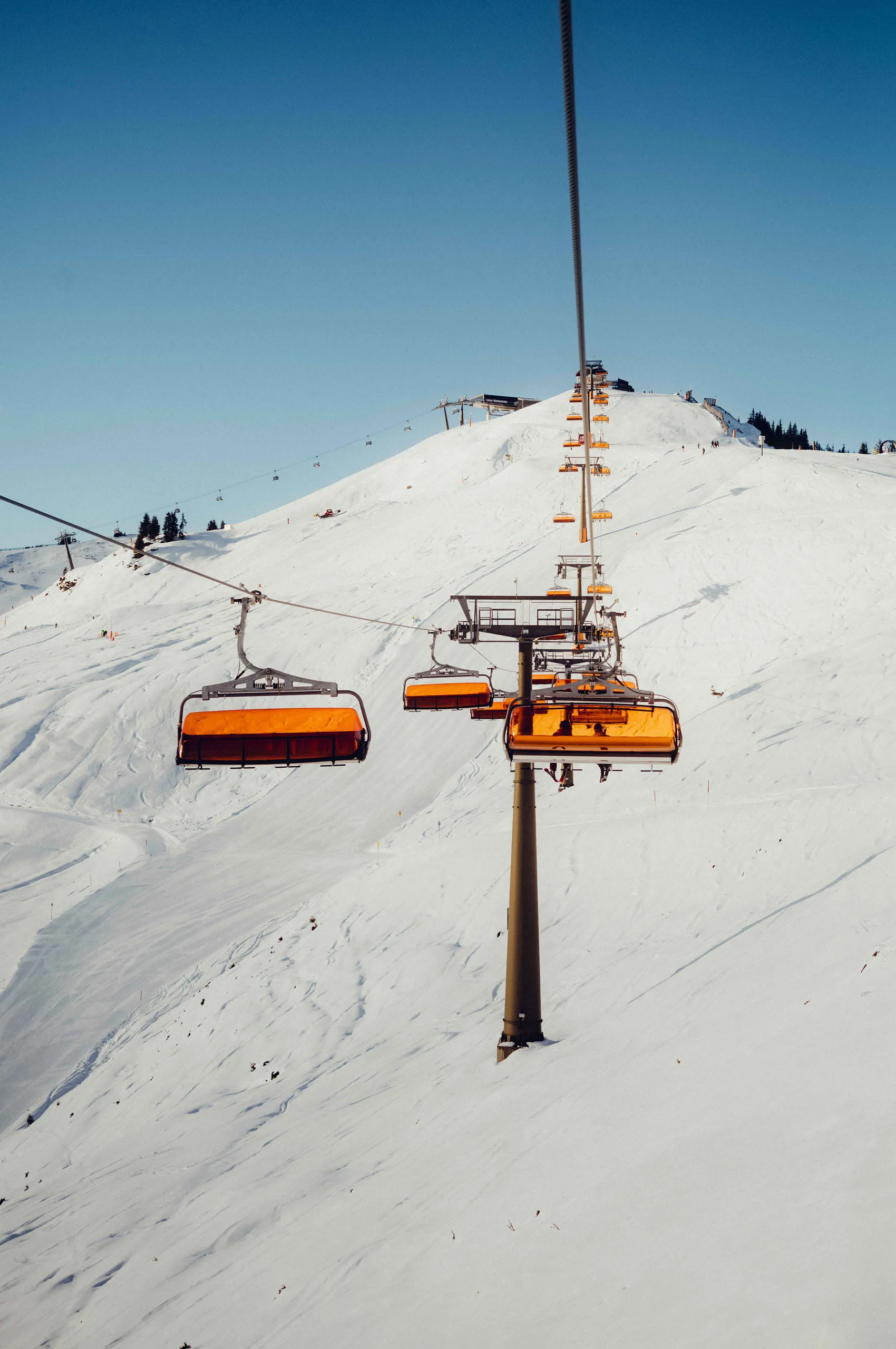 Skilift mit orangefarbenen Lifte über den verschneiten Hang
