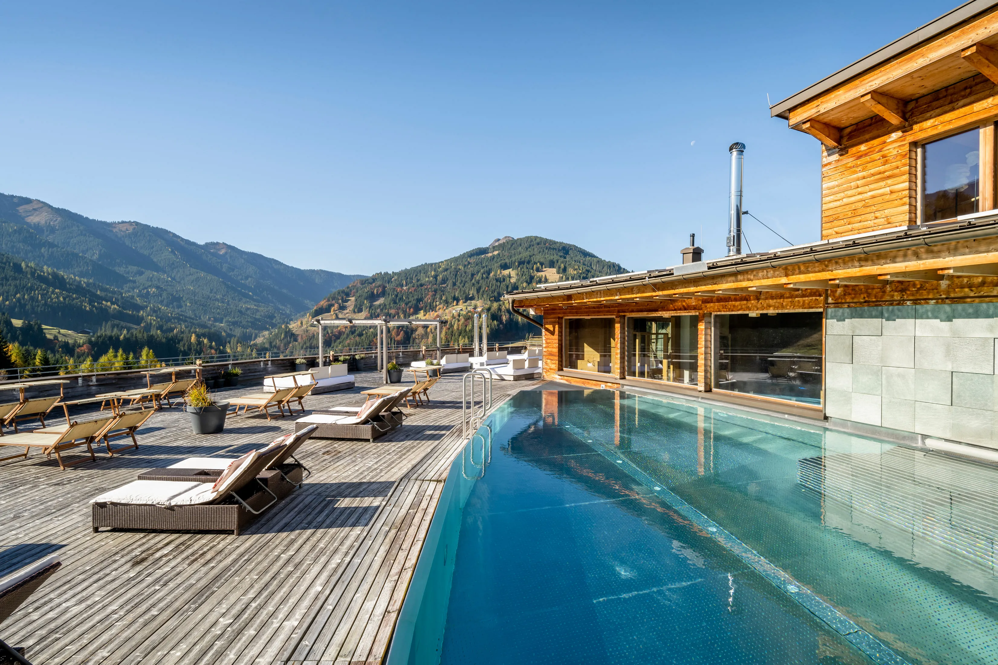 Poolbereich mit Bergblick im Holzhotel Forsthofalm, Leogang