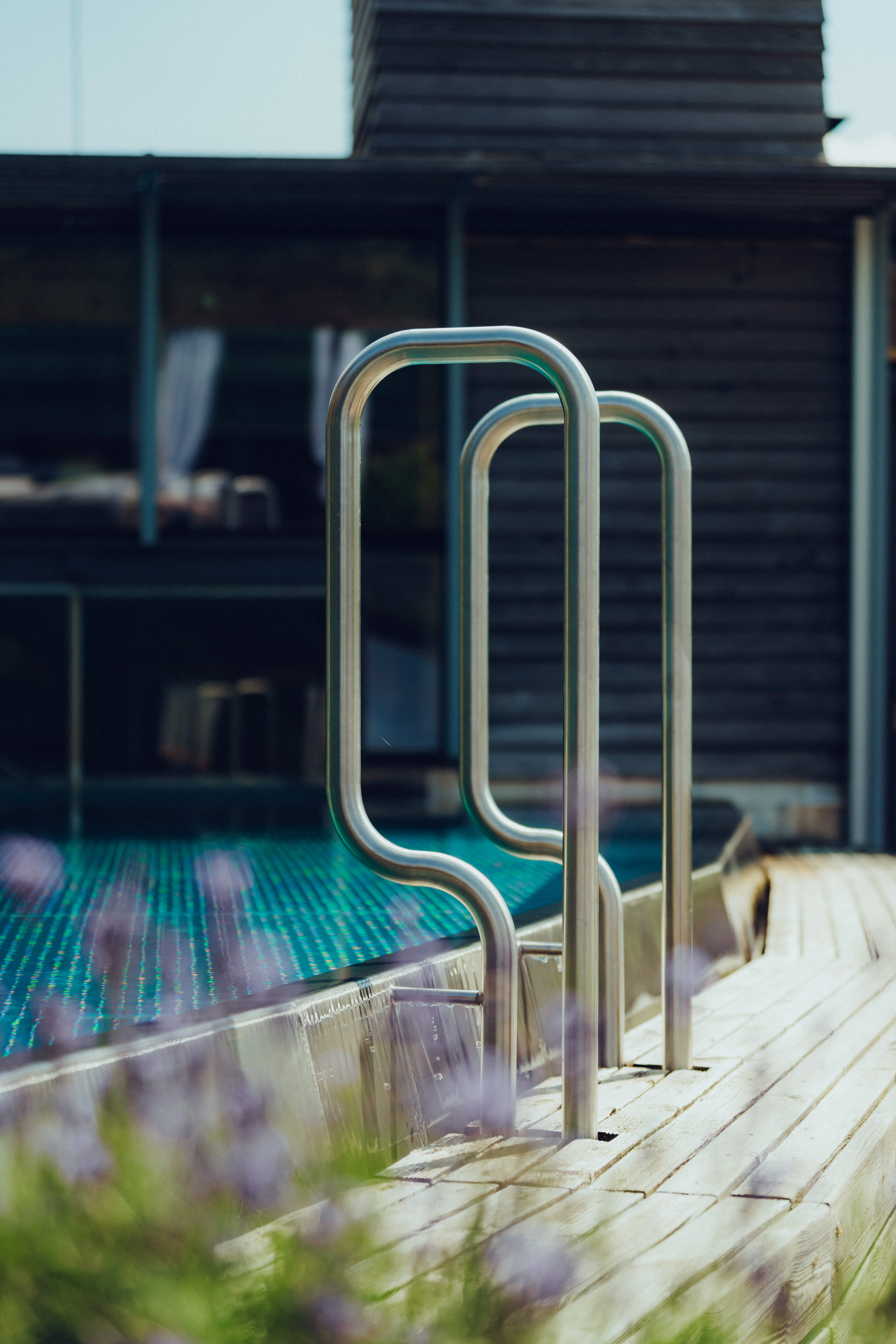 Edelstahl-Handlauf neben einem Pool mit Holzdeck