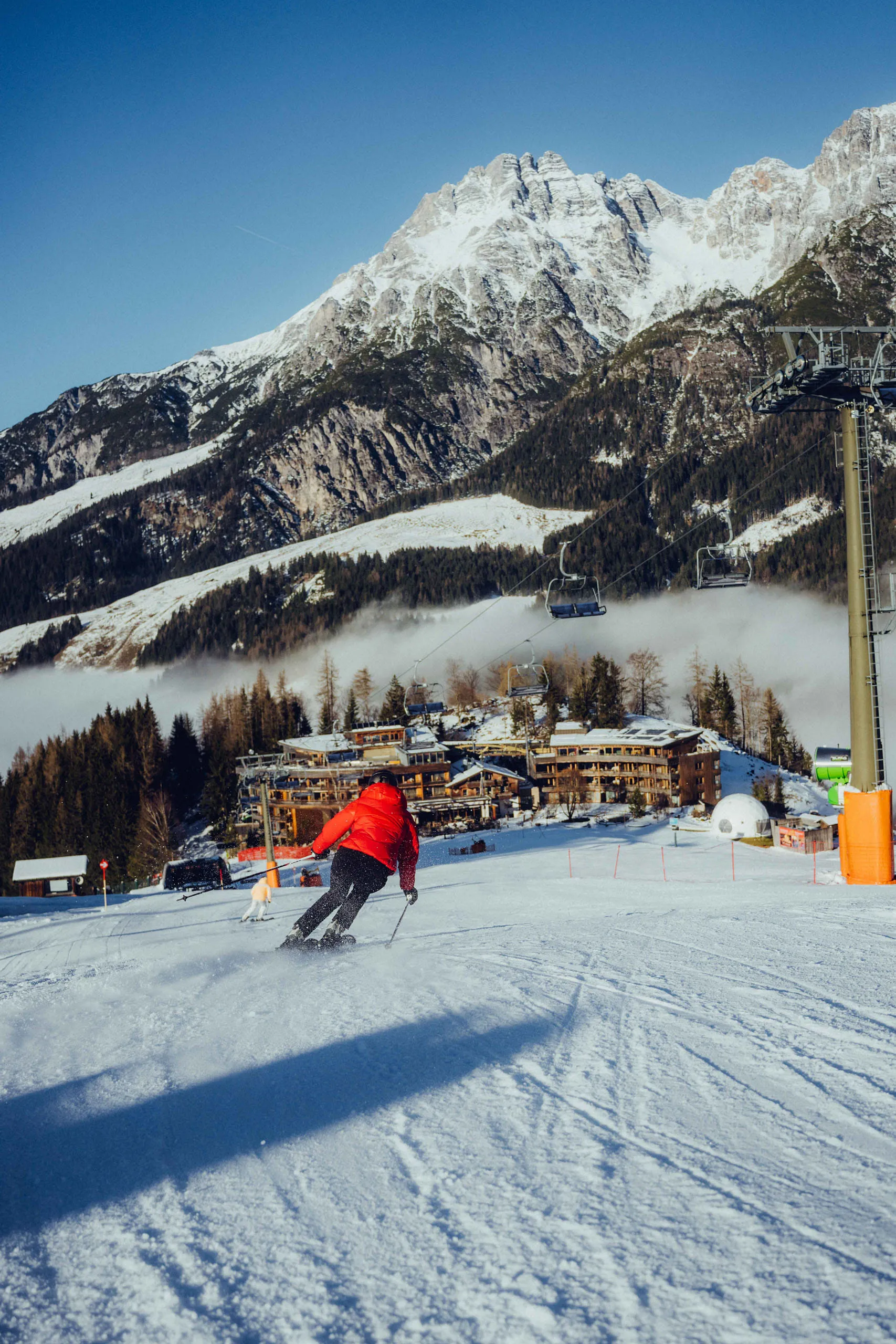 Skifahrer vor dem Holzhotel Forsthofalm in Leogang