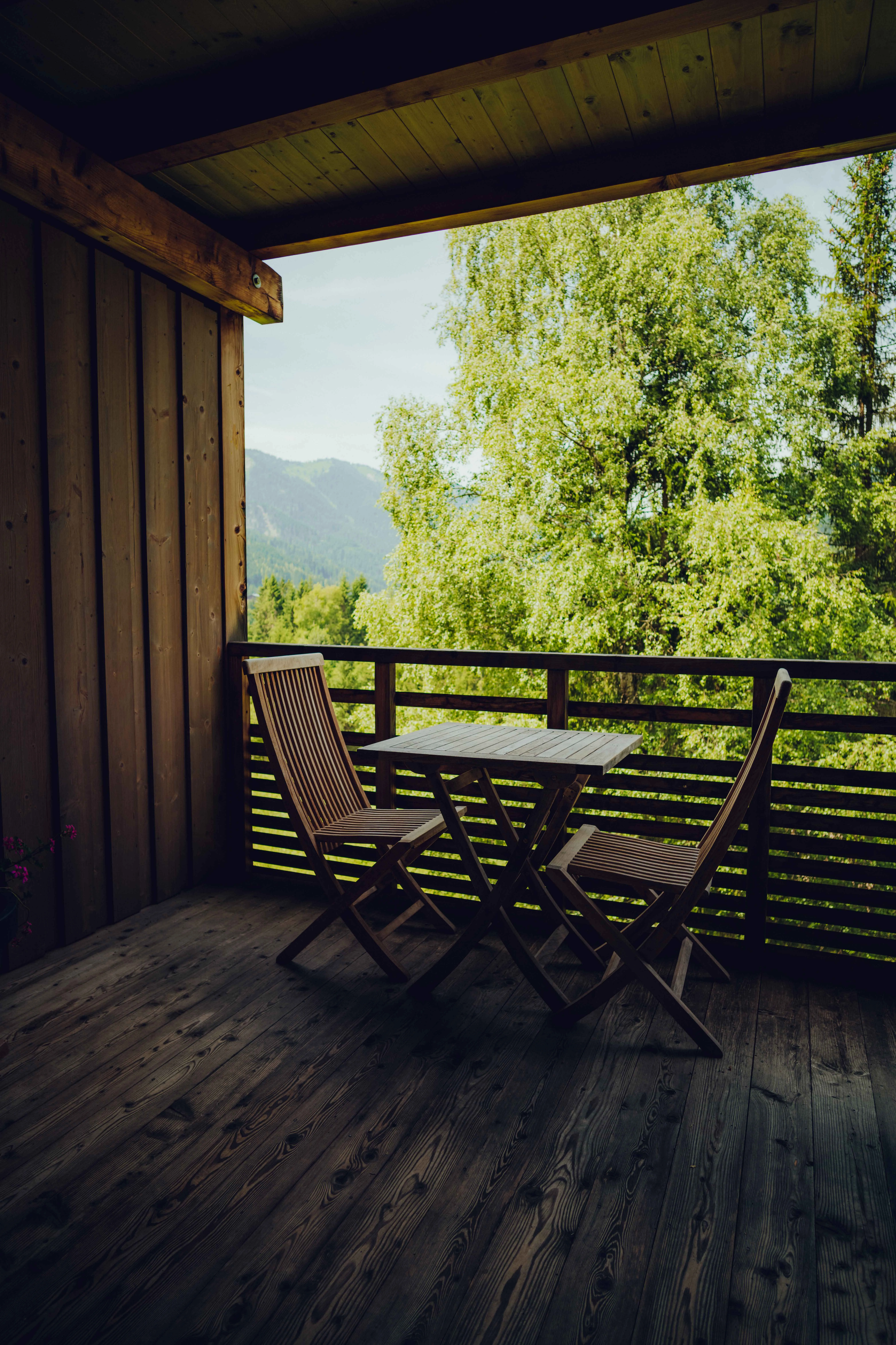 Holzveranda mit Tisch und Stühlen, Blick ins Grüne