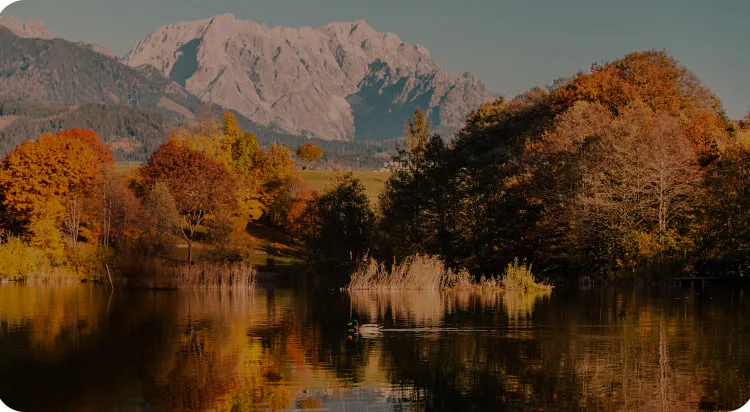 Berglandschaft mit farbenfrohen Bäumen und spiegelndem See