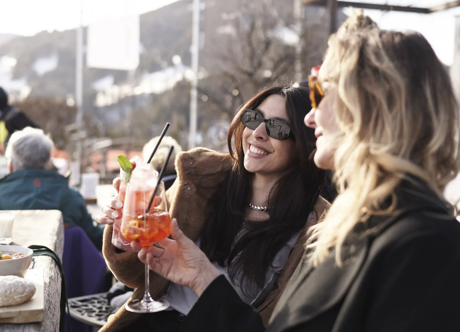 Zwei Frauen genießen Cocktails in der Holzhotel Forsthofalm in Leogang.