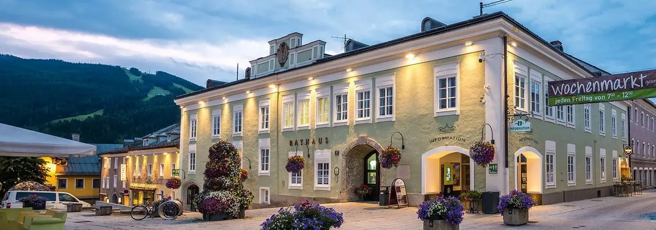 Blick auf ein historisches Gebäude in Radstadt mit Blumen und Abendbeleuchtung