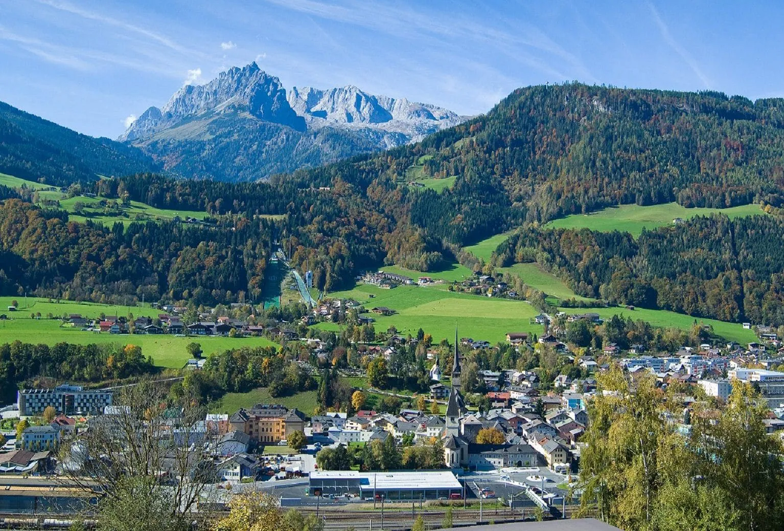 Blick auf Bischofshofen mit Bergen im Hintergrund und grüne Landschaft